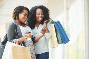 Happy African-American women reading message on smartphone