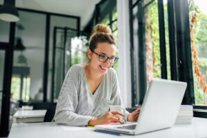 Girl in casual clothing using laptop.