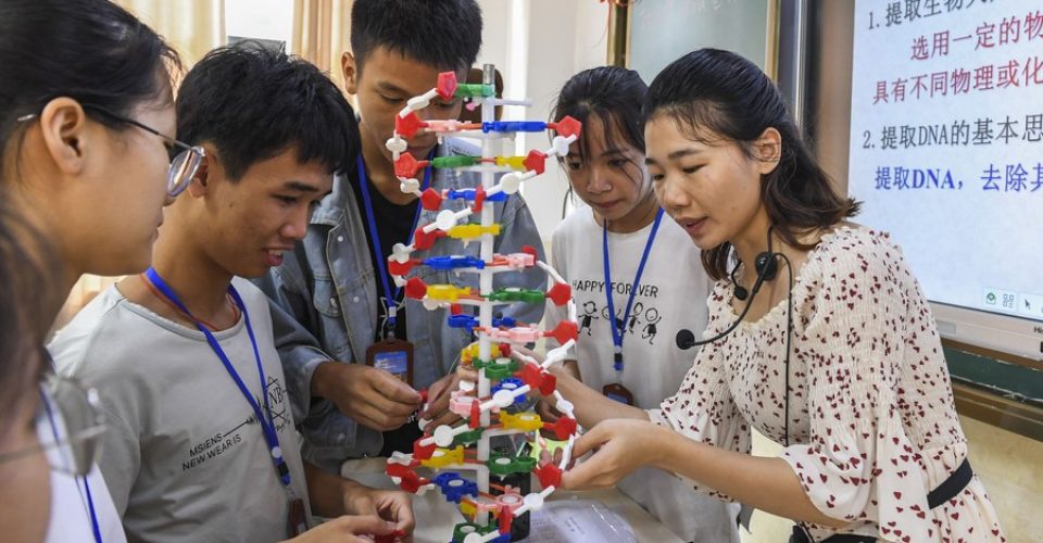 Foto: Uma professora e alunos estudam um modelo de estrutura de DNA em uma escola de ensino médio no distrito de Xingye, na Região Autônoma da Etnia Zhuang de Guangxi, no sul da China, em 29 de maio de 2020. (Xinhua/Cao Yiming)