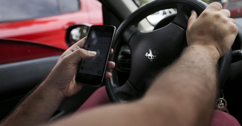 celular homem dirigindo no volante carro